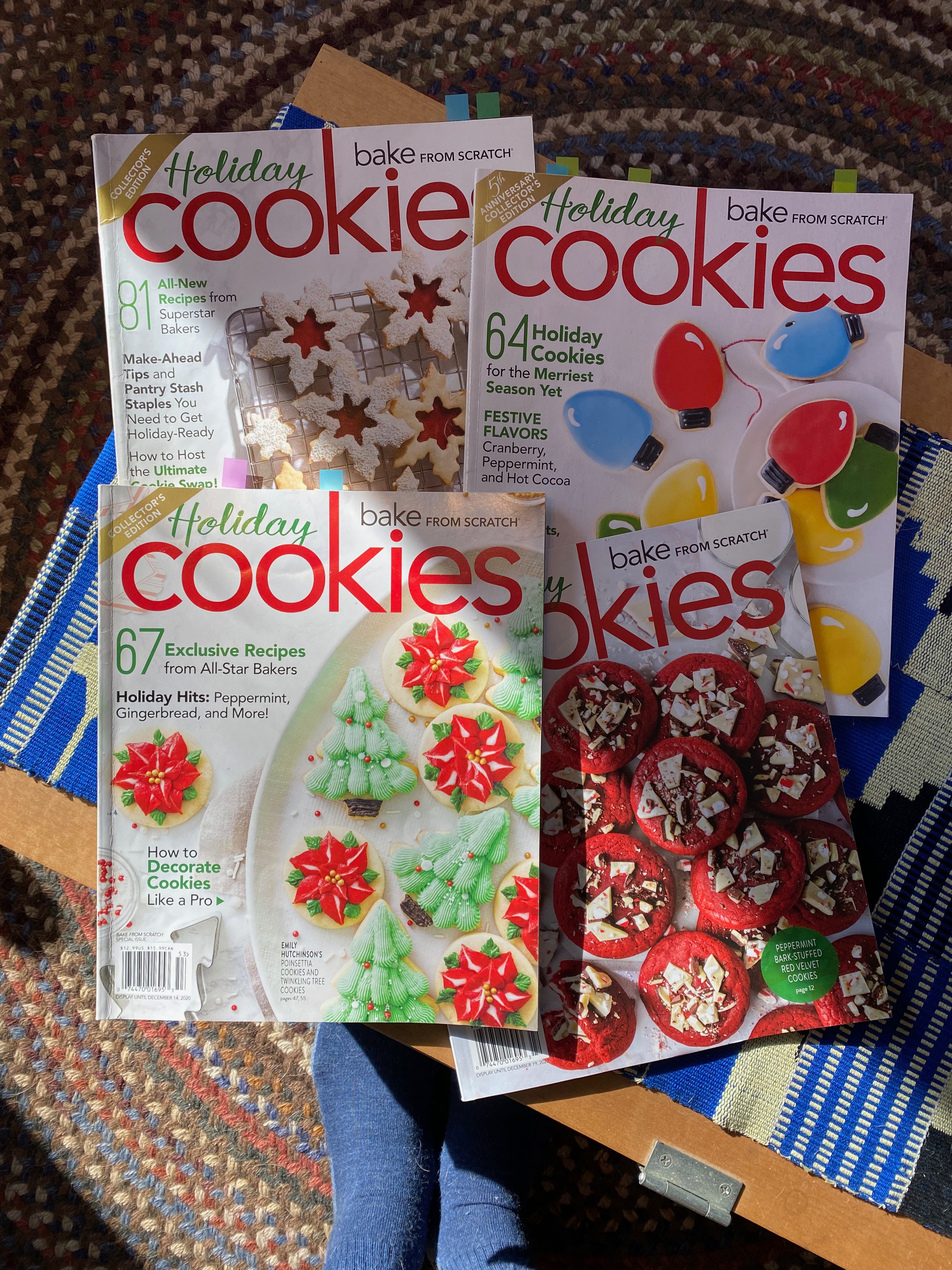 Four Bake From Scratch cookie magazines spread out on a coffee table. My socked feet are visible at the bottom of the frame.