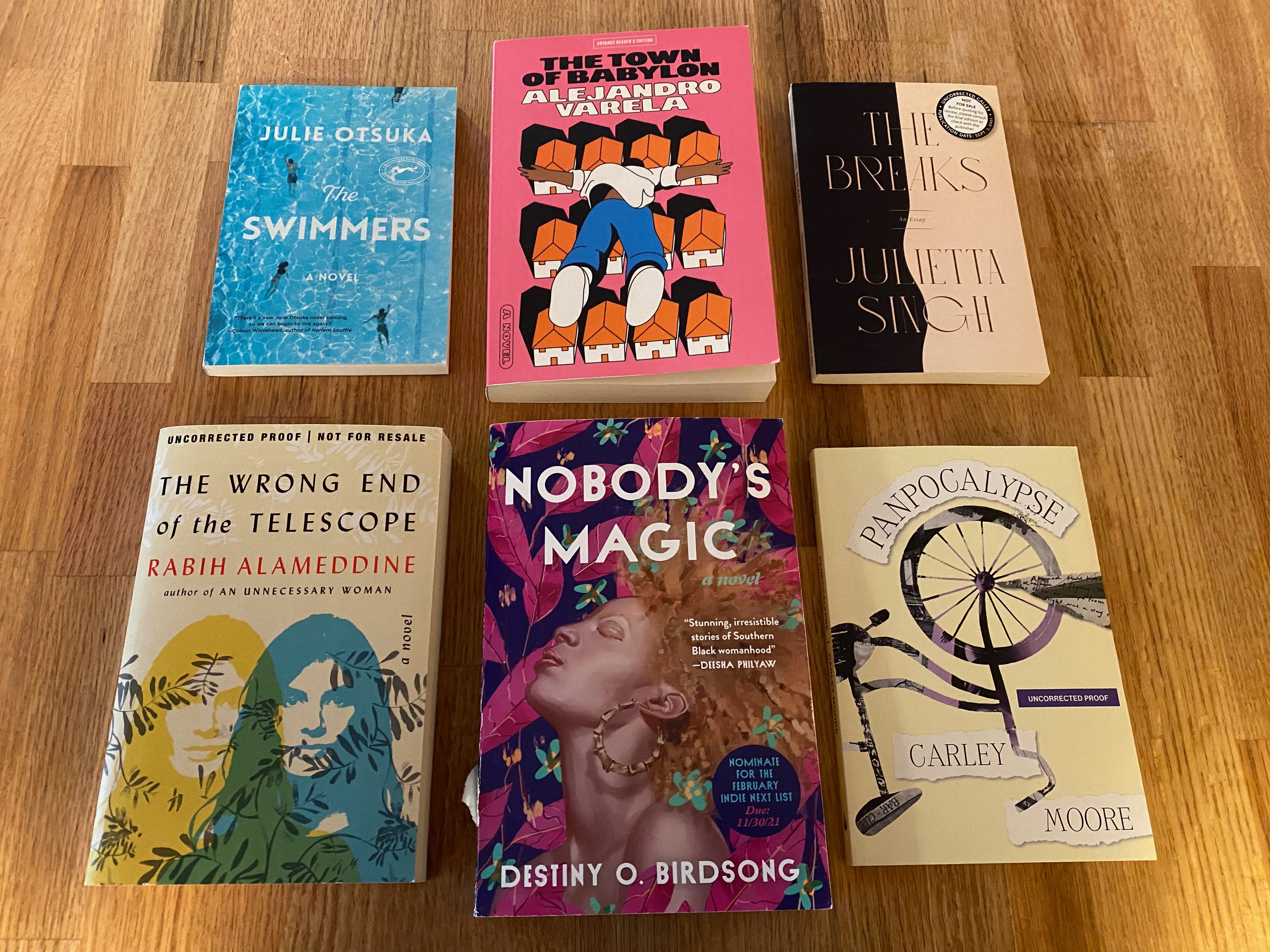 The six books listed below laid out in a grid on a wooden counter.