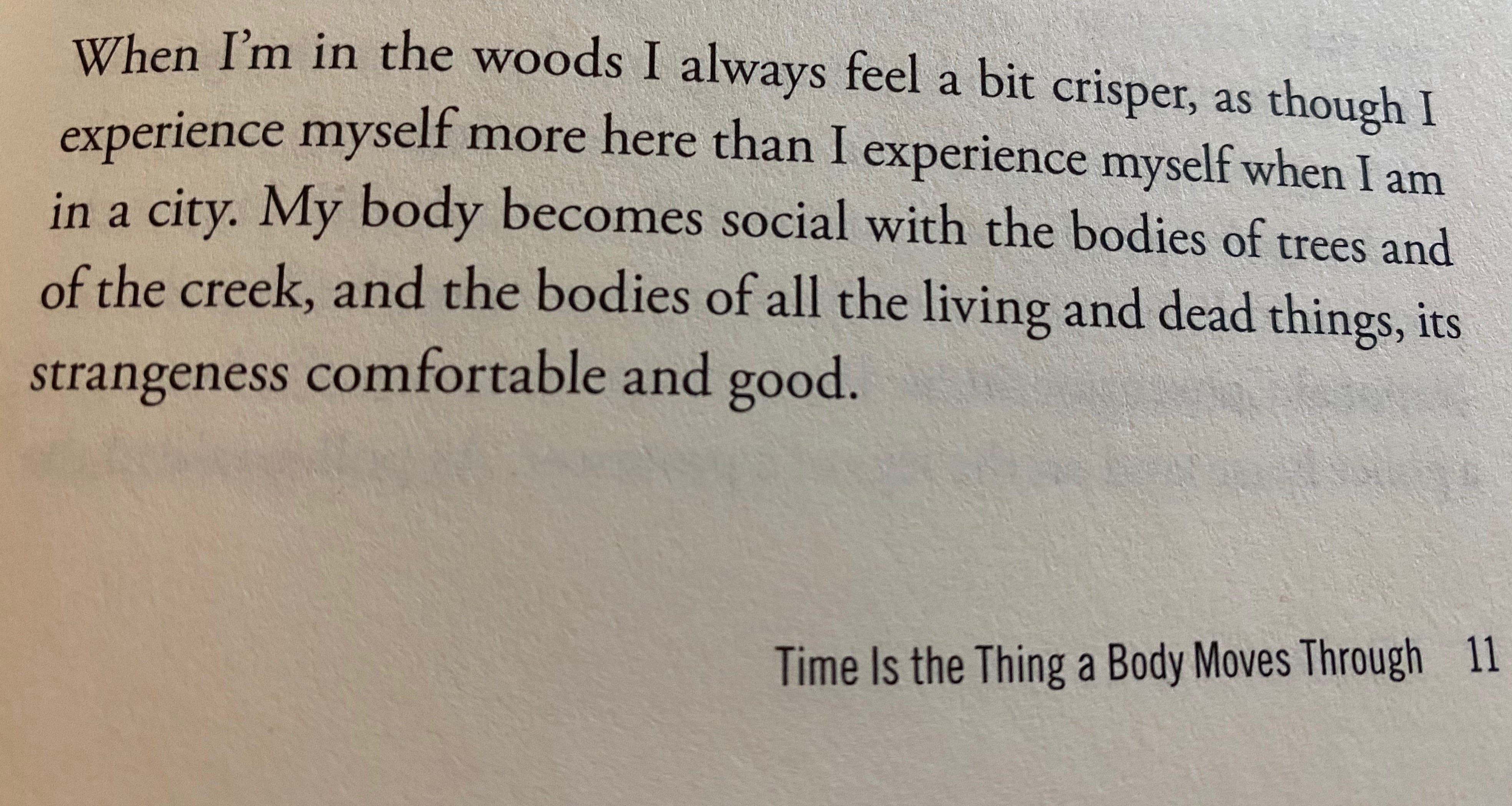 A photo of a page from Time Is the Thing a Body Moves Through showing this text: “When I’m in the woods I always feel a bit crisper, as though I experience myself more here than I experience myself when I am in a city. My body becomes social with the bodies of trees and of the creek, and the bodies of all the living and dead things, its strangeness comfortable and good.”