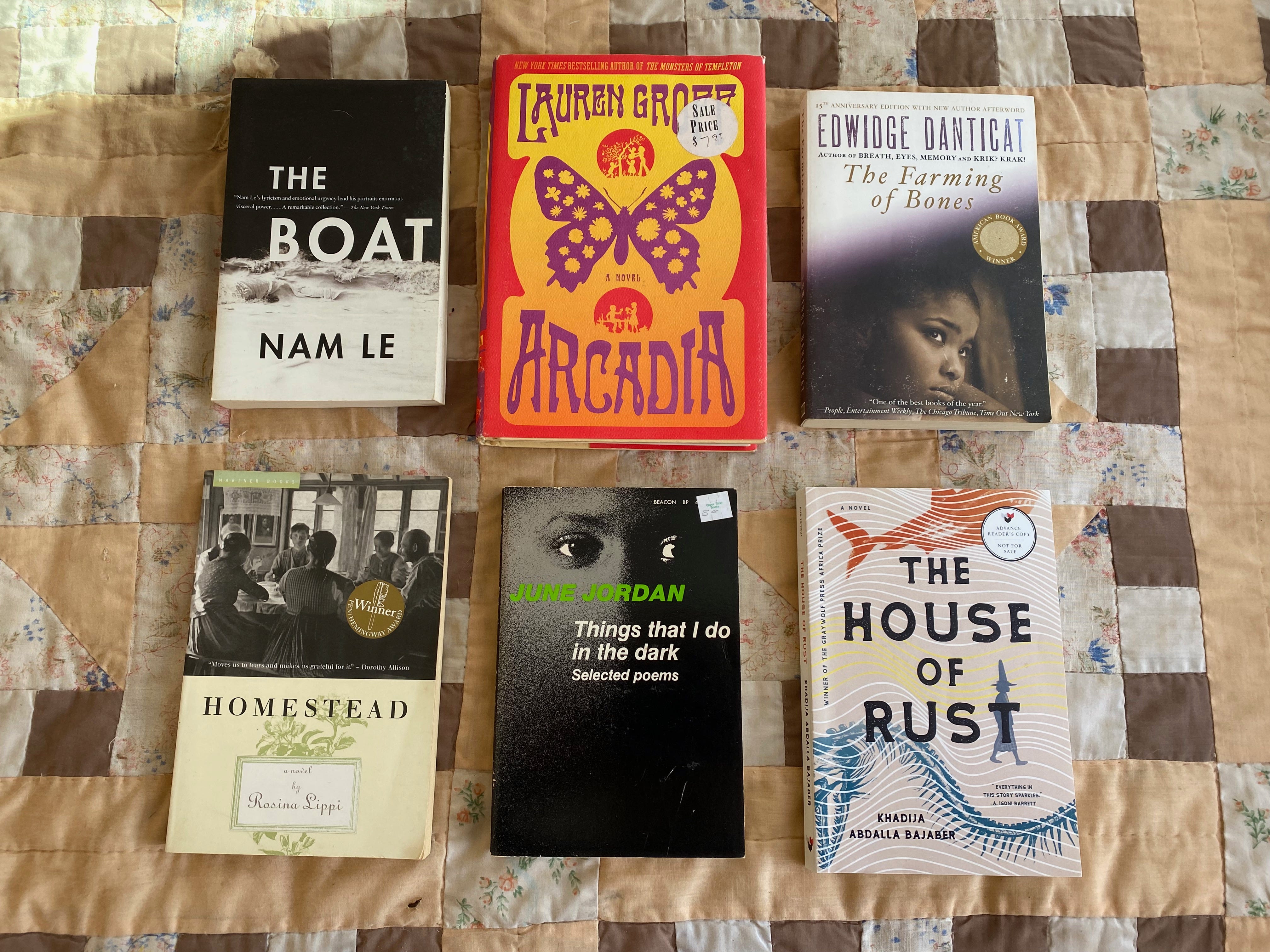 The six listed books arranged in two rows on a brown and tan quilt.