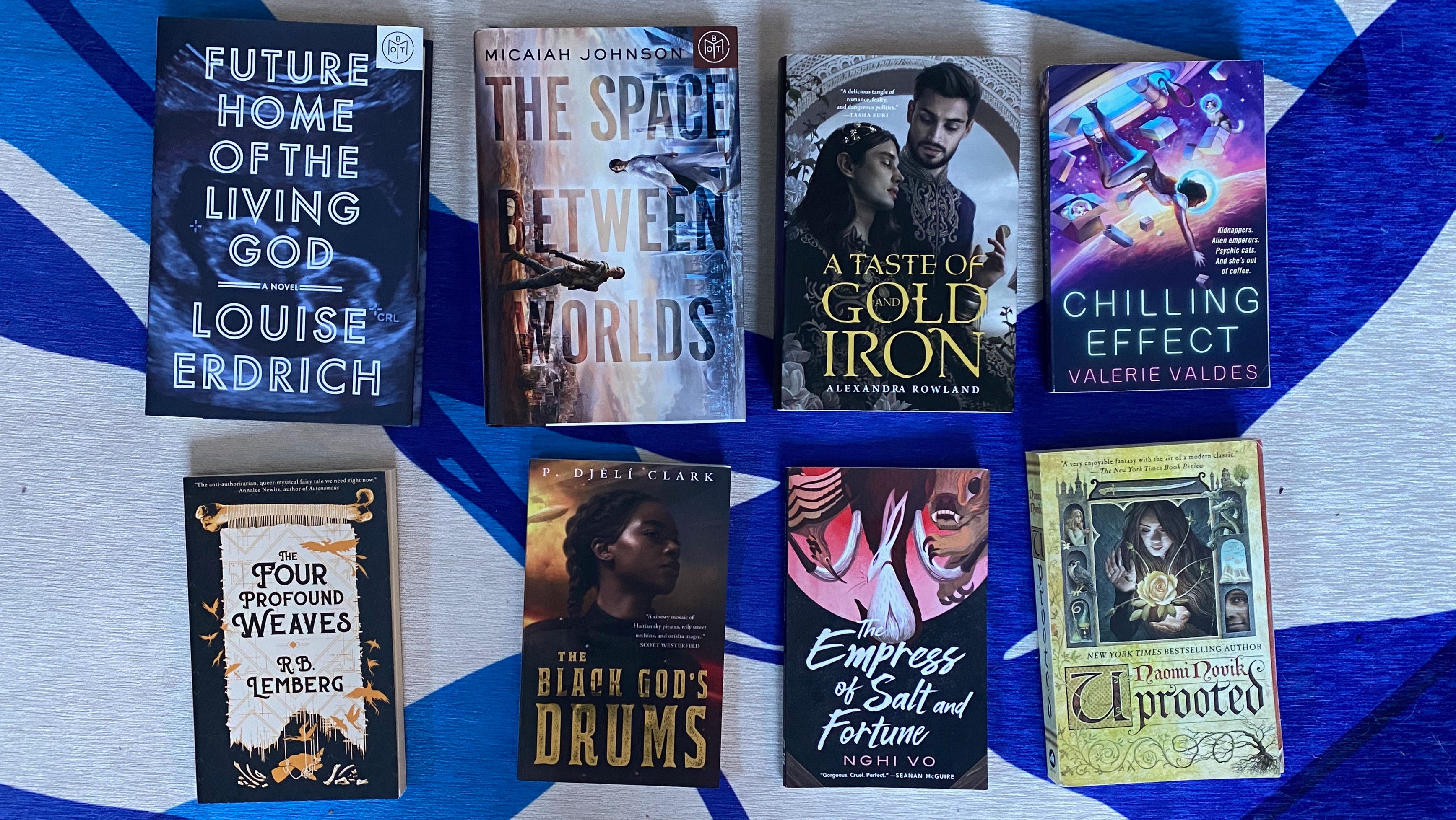 The listed books spread out in a row on a blue and white rug.